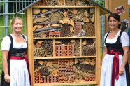 Zwei Frauen stehen neben Insektenhotel