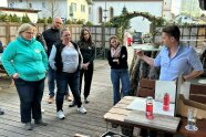 Mann steht vor einer Gruppe Personen und hält einen Vortrag