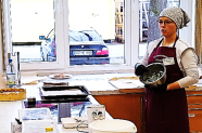 Frau in Küchenschürze mit Backutensilien