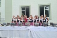 Frauen in Trachten hinter einem Buffet.