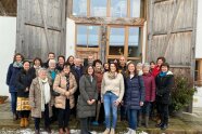 Personengruppe vor Fensterfront eines historischen Stadels