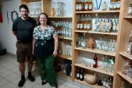 Mann und Frau stehen vor Regalen mit unterschiedlichen Schnapsflaschen